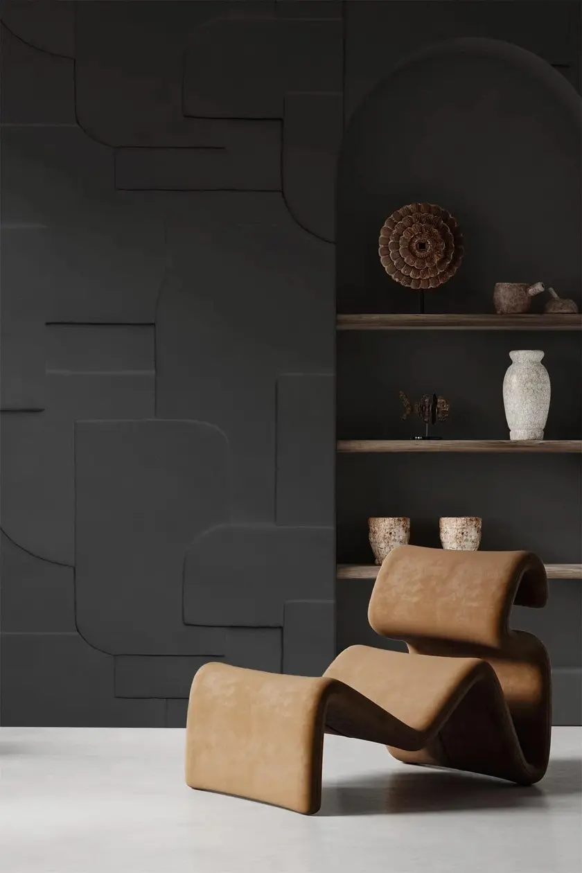 Sculptural tan lounge chair against a charcoal relief wall.